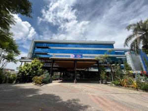 a large blue building with a palm tree in front of it at WYNS Hotel Bandung in Bandung