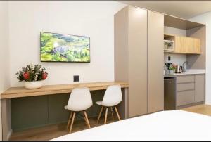 une cuisine avec deux chaises blanches et un comptoir dans une pièce dans l'établissement Toms holidayInn, à Cheruvalli