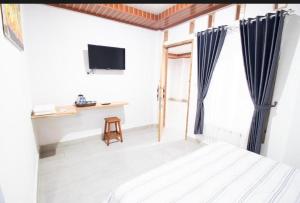 une chambre avec un lit, un bureau et une télévision dans l'établissement Toms holidayInn, à Cheruvalli