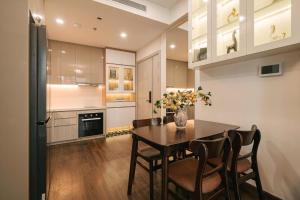 eine Küche mit einem Tisch mit Stühlen und einer Vase aus Blumen in der Unterkunft Hermes Housing- Masteri West Heights in Hanoi + 61 Fotos
