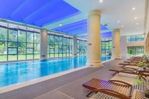 廈門市にあるFliport Garden Hotel Xiamen Airportの椅子と窓のある建物内のプール