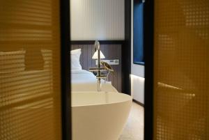 a bathroom with a white sink and a bed at Grey Parrot Resort Hotel in Chengdu +34 photos
