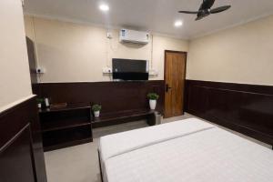 a bedroom with a bed and a flat screen tv at Landmark Inn in Lanka +4 photos