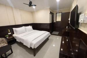 a bedroom with a bed and a chair in it at Landmark Inn in Lanka
