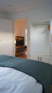 Un dormitorio con una cama y un televisor de pantalla plana. en Haus Biederstaedt & LivJana, en Ottersberg