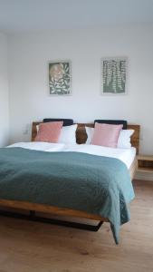 Un dormitorio con una cama grande con sábanas rosas y verdes. en Haus Biederstaedt & LivJana, en Ottersberg