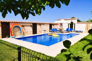 einen Pool im Hinterhof mit blauen Stühlen in der Unterkunft La Casona del Bullaque in El Robledo