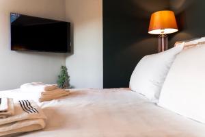 een slaapkamer met een bed en een tv aan de muur bij Villa Octogon Câmpina in Campina