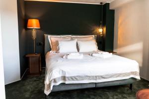a bedroom with a large white bed with two towels on it at Villa Octogon Câmpina in Câmpina +70 photos