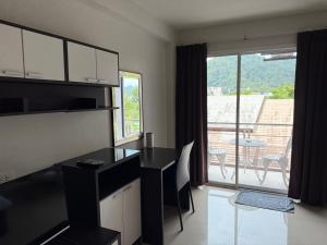 een keuken met een bureau en uitzicht op een balkon bij Aonang Mountain View A1 in Ao Nang Beach