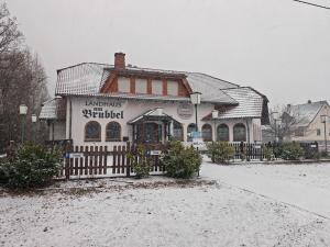 a building with a fence in the snow at Landhaus am Brubbel in Wallenborn
