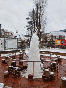 a snow covered fountain in a park in the snow at Landhaus am Brubbel in Wallenborn +8 photos