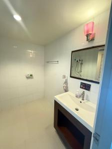 een witte badkamer met een wastafel en een spiegel bij Aonang Mountain View A1 in Ao Nang Beach