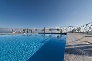 Ein großer blauer Swimmingpool mit einer Brücke im Hintergrund in der Unterkunft Cora Sun Apart-Hotel in St Paul's Bay
