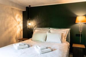 een slaapkamer met een wit bed met twee handdoeken erop bij Villa Octogon Câmpina in Campina