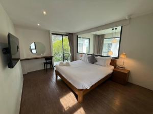 a bedroom with a large bed and a mirror at Meet Up Villa in Ban Nai Khao