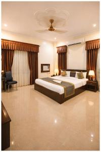 een grote slaapkamer met een bed en een stoel bij Hotel A- Grand Residency Near Vishwanath temple - Free Wi-Fi & Restaurants - Air conditioning Room- Best Budget Hotel in Varanasi