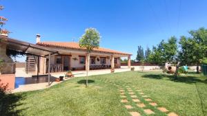 ein Haus mit einem Rasen davor in der Unterkunft La Casona del Bullaque in El Robledo