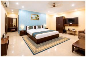 een slaapkamer met een bed en een woonkamer bij Hotel A- Grand Residency Near Vishwanath temple - Free Wi-Fi & Restaurants - Air conditioning Room- Best Budget Hotel in Varanasi