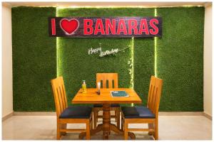 een tafel en stoelen voor een groene muur bij Hotel A- Grand Residency Near Vishwanath temple - Free Wi-Fi & Restaurants - Air conditioning Room- Best Budget Hotel in Varanasi +15 foto's
