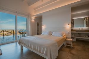 a bedroom with a large bed and a large window at Agroturismo Son Vives Menorca - Adults Only in Ferreries +90 photos