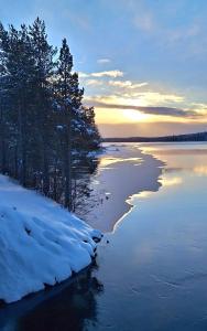 a view of a river with snow and trees at Smedjan in Mellanström +29 photos