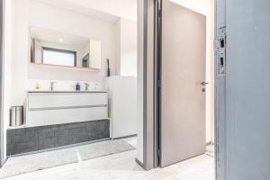 une salle de bains avec un lavabo et un miroir dans l'établissement Lovely Private Rooms in 5BR shared Apartment in the Heart of Ghent for Groups, à Gand