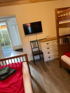 a bedroom with a bunk bed and a television on the wall at Traumhaus am See 2 in Rieden