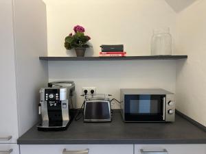 encimera de cocina con microondas y cafetera en 2 Zi Wohnung, zentrale Lage mit Parkplatz, 15 min vom Hbf Hamburg, en Pinneberg 17 fotos más