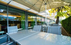 a table with white chairs and an umbrella at Ibercity Wien Schönbrunn in Vienna