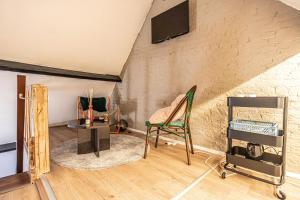 un salon avec une télévision et une chaise dans l'établissement Lovely Private Rooms in 5BR shared Apartment in the Heart of Ghent for Groups, à Gand
