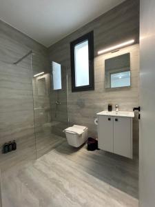a bathroom with a toilet and a sink and a shower at AFRODITI Living in Nicosia