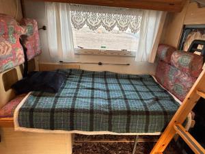 Bett in einem kleinen Zimmer mit Fenster in der Unterkunft Palmi Caravan in Poris de Abona