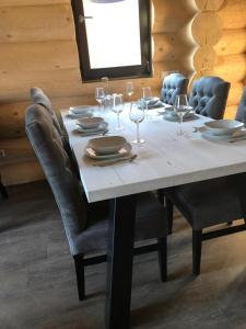 a dining room table with chairs and wine glasses at Chalet Marmotte am Nassfeld in Hermagor