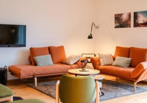 ein Wohnzimmer mit orangefarbenen Sofas und einem Fernseher in der Unterkunft janzweitnah in Gerolstein