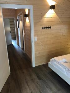 a bedroom with a wooden wall with a bed and lights at Chalet Marmotte am Nassfeld in Hermagor