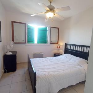 une chambre avec un lit et un ventilateur de plafond dans l'établissement 4HC65 Appartement avec vue sur baie de Collioure, à Collioure 15 autres photos