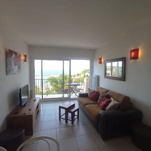 un salon avec un canapé et une télévision dans l'établissement 4HC65 Appartement avec vue sur baie de Collioure, à Collioure