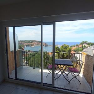 un balcon avec une table et des chaises et une vue sur l'océan dans l'établissement 4HC65 Appartement avec vue sur baie de Collioure, à Collioure