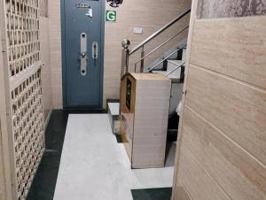 a hallway with a blue door and stairs at Hotel Ravi Residency in Jalandhar