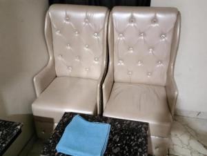 a white chair with a table and a blue pillow at Hotel Ravi Residency in Jalandhar