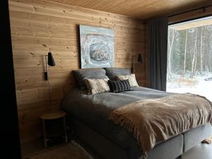 a bedroom with a bed in a wooden wall at Hulppea merenranta hirsitalo in Oulu