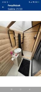 een kleine badkamer met een toilet in een tiny house bij Fenyőházak in Buzsák