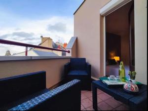 ein Balkon mit zwei Stühlen und einem Tisch und einem Bett in der Unterkunft Le Duplex du Marche-centre-parking prive-balcon in Châteauroux