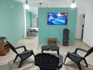 una camera con sedie e TV a parete di Casa tinajas a Santiago del Estero