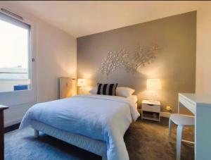 ein Schlafzimmer mit einem großen weißen Bett und einem Fenster in der Unterkunft Le Duplex du Marche-centre-parking prive-balcon in Châteauroux