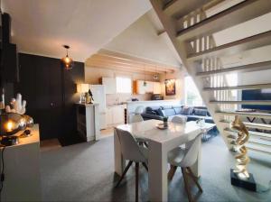 eine Küche und ein Wohnzimmer mit einem weißen Tisch und Stühlen in der Unterkunft Le Duplex du Marche-centre-parking prive-balcon in Châteauroux