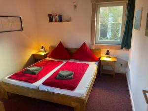 a bedroom with a bed with red sheets and two lamps at Traumhaus am See in Rieden