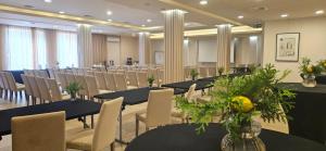 einen Konferenzraum mit Tischen, Stühlen und Blumen in der Unterkunft Hotel Petropol in Płock