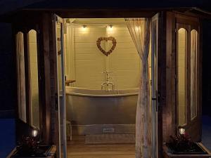 a bathroom with a tub with a heart on the wall at Y Cwlwm - The Celtic Knot in Lampeter +12 photos